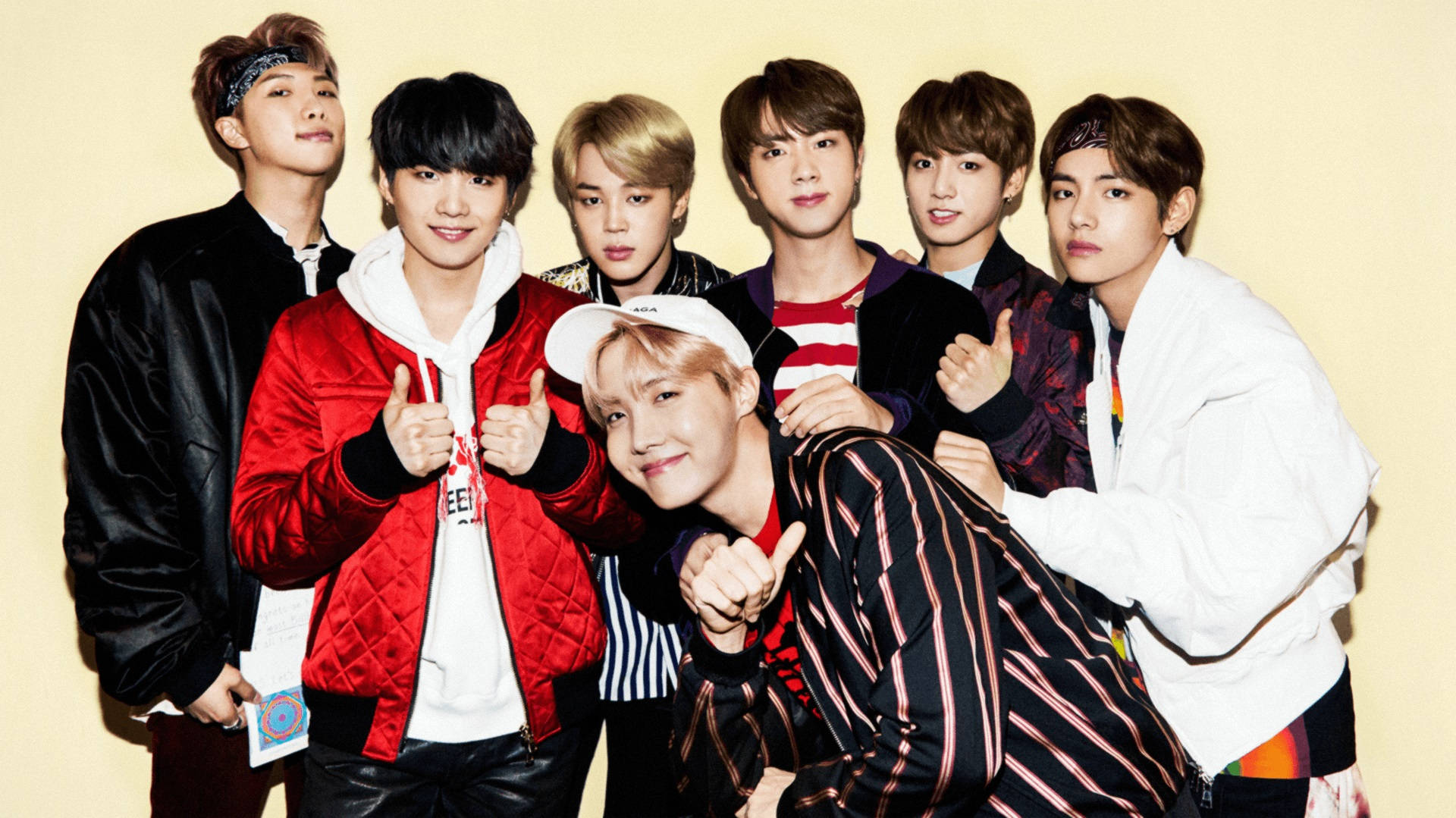 Милі BTS позують на жовтому фоні Шпалери