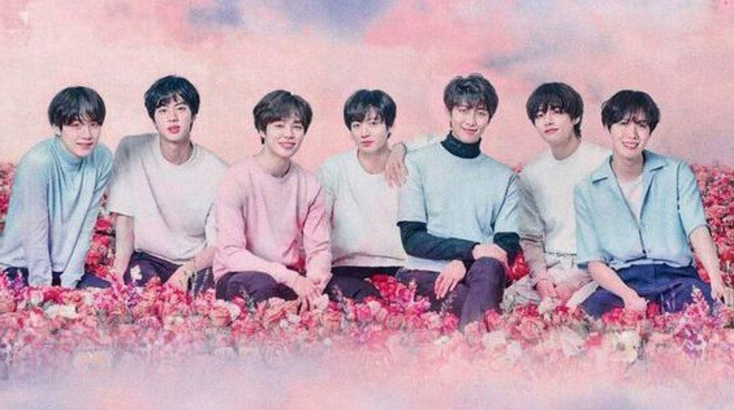 Мила група BTS на рожевому полі квітів Шпалери