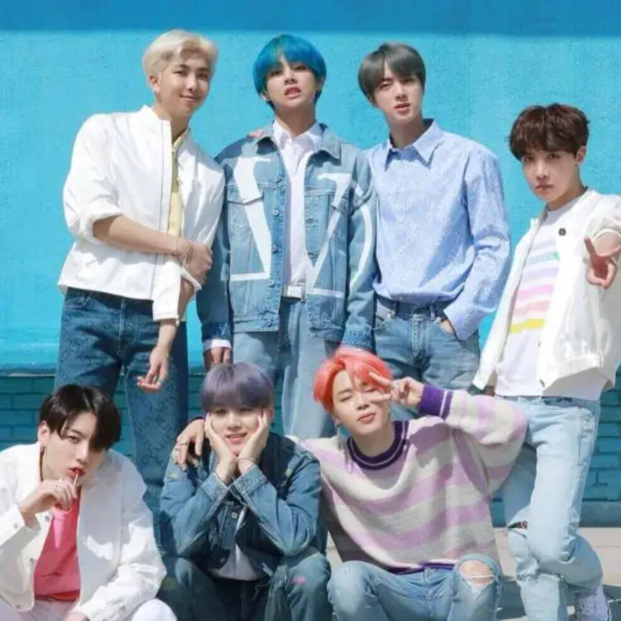 Милі учасники BTS позують разом біля синьої стіни Шпалери