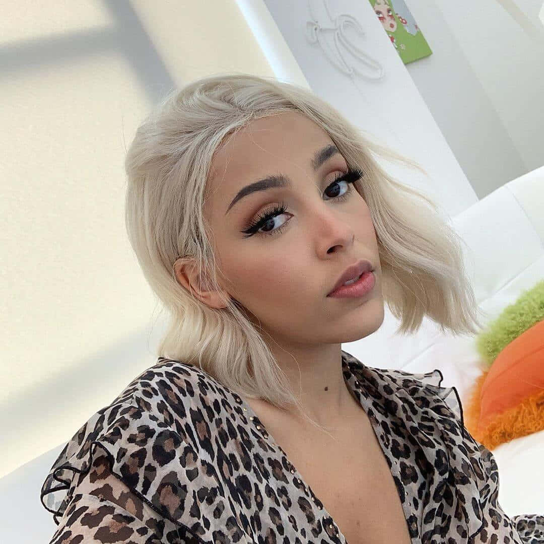 Doja Cat демонструє свою красу з блискучими тінями для повік та яскравою посмішкою. Шпалери