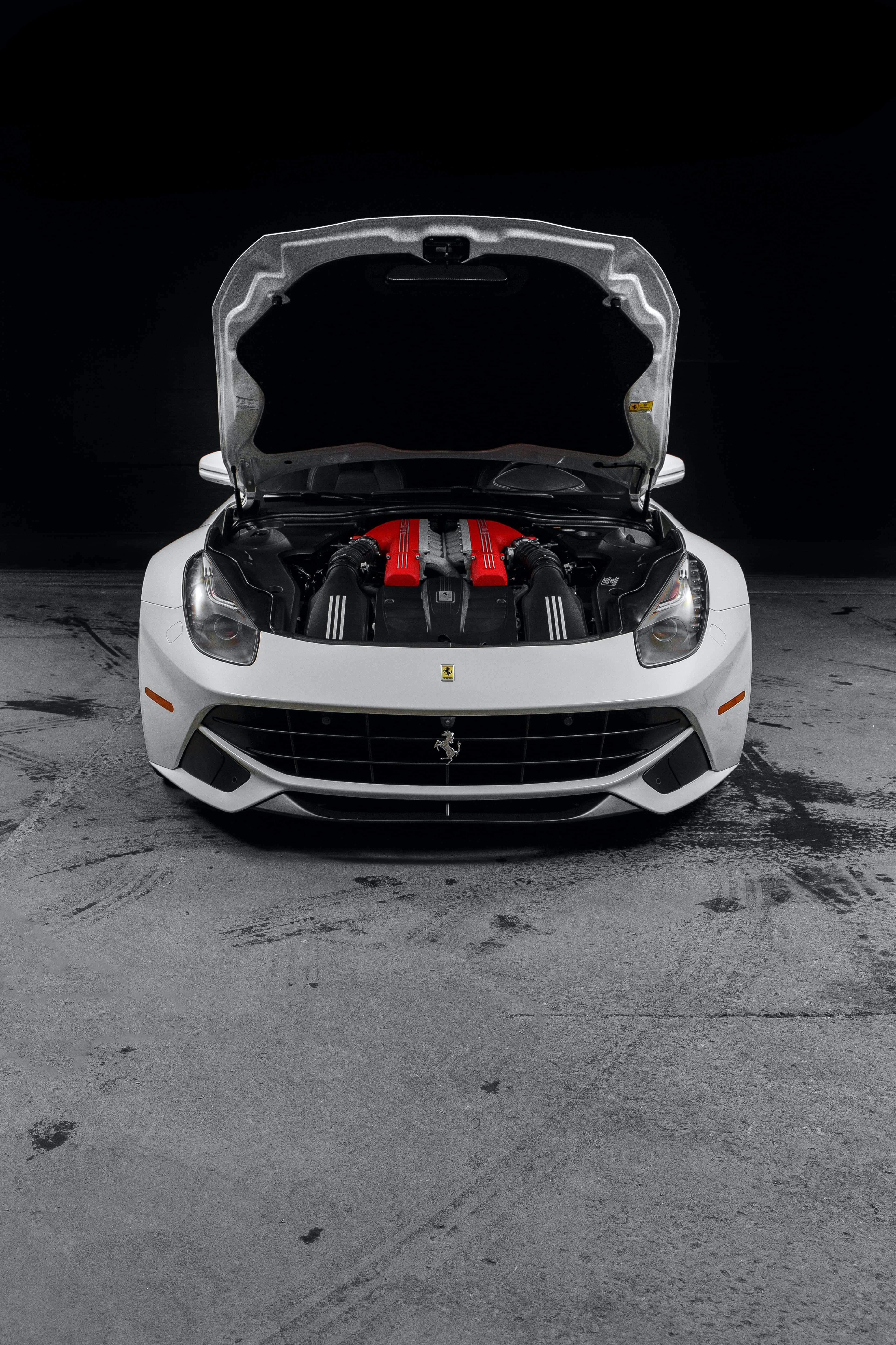 Величина швидкого червоного Ferrari на фоне сумеречного неба Шпалери