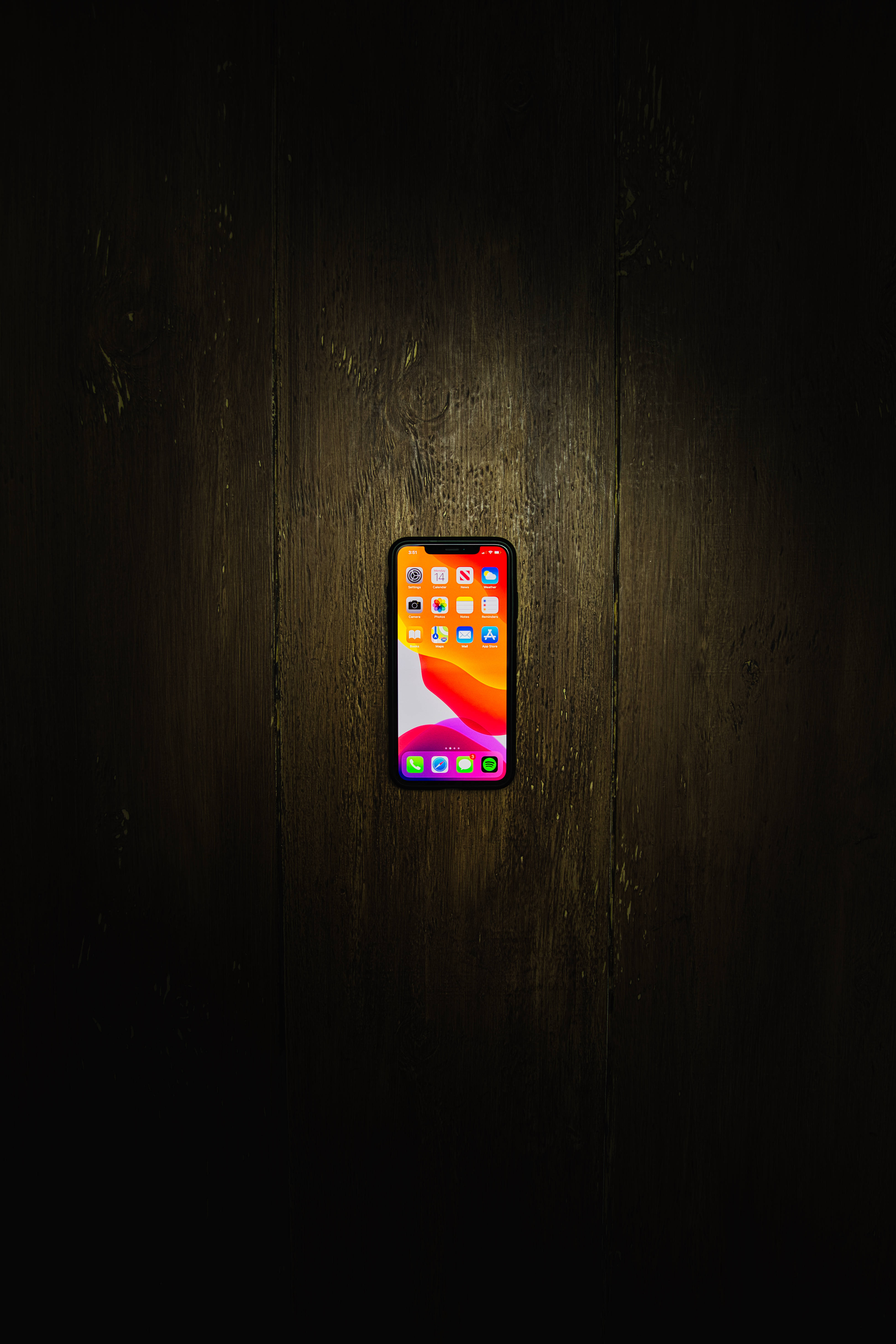 iPhone Xs Max на дерев'яній підлогі Шпалери