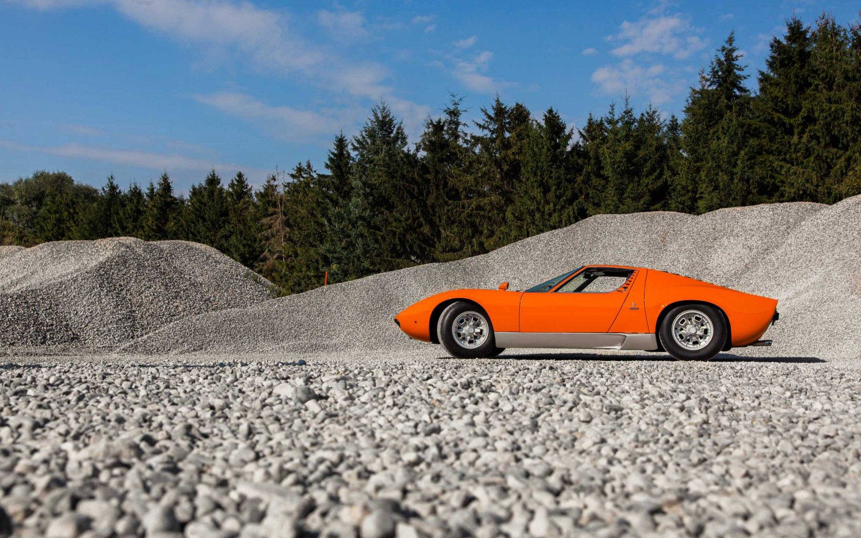 Вишуканий оранжевий Lamborghini Miura на гравійній дорозі. Шпалери