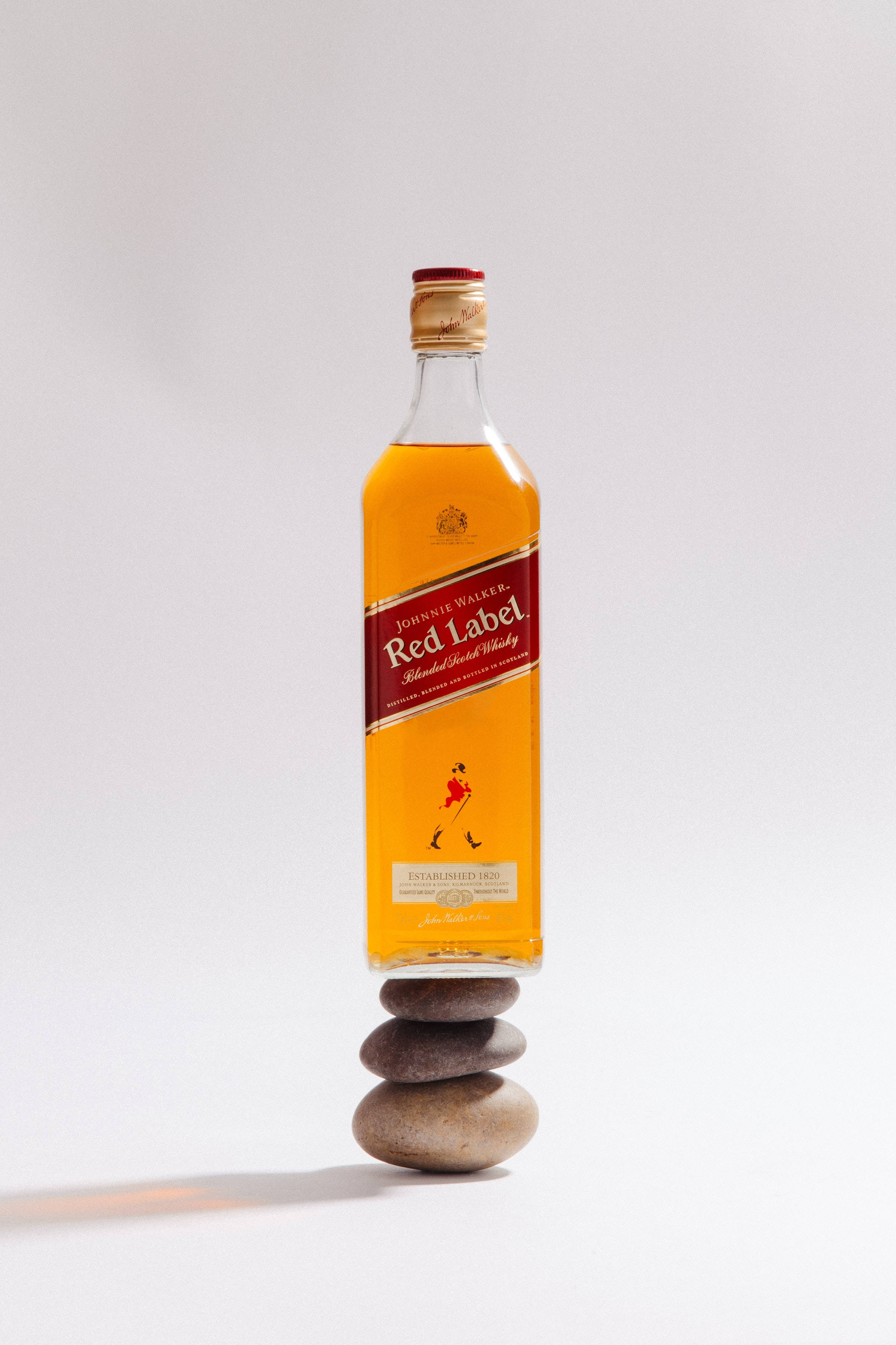 Бутылка виски Red Label на стопке камней Шпалери