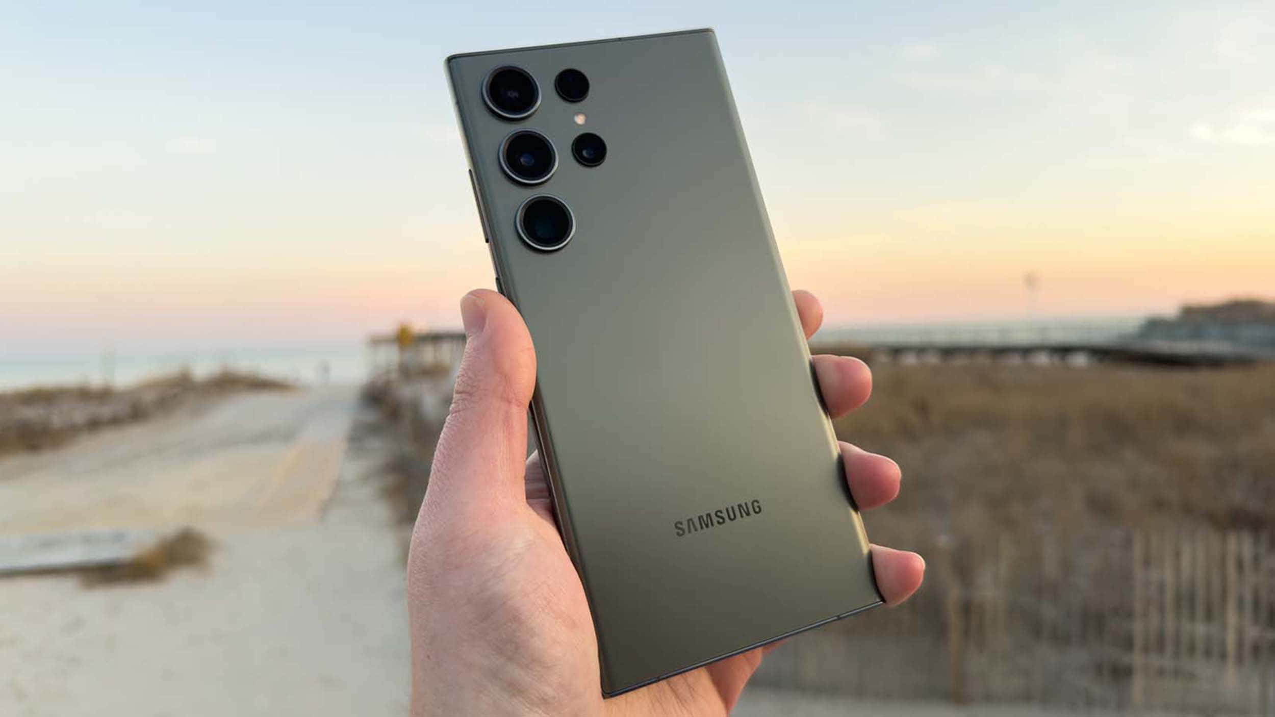 Samsung S23 Ultra в руці на пляжному фоні Шпалери