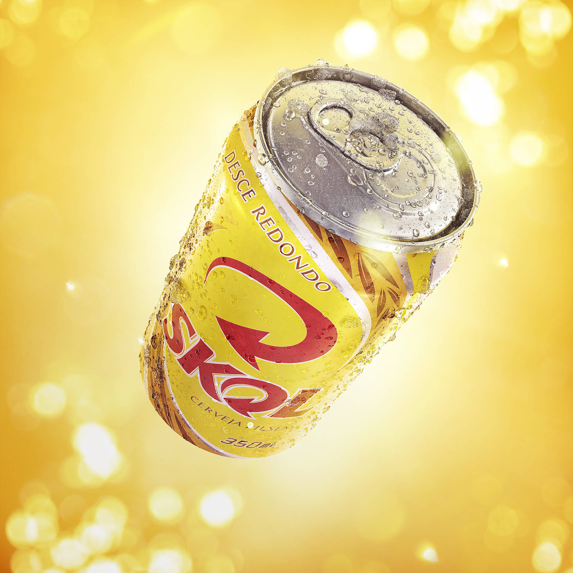 Охлажденная банка пива Skol на ярком желтом фоне Шпалери