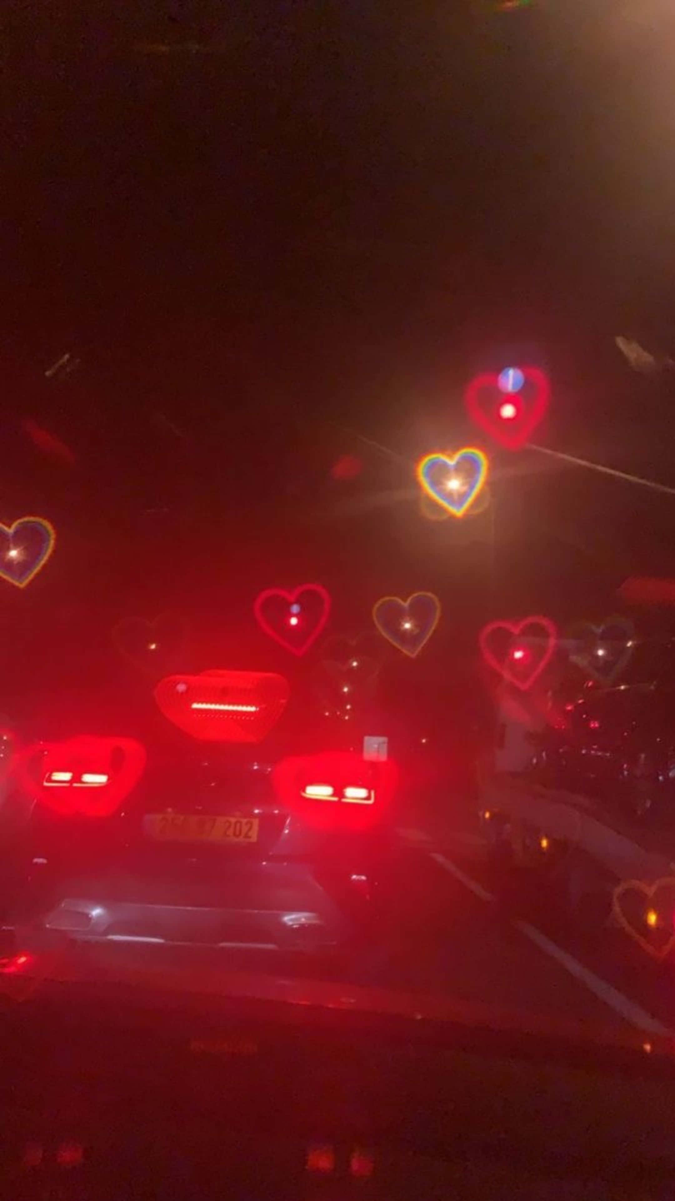 автомобіль, що їде дорогою вночі з серцями на лобовому склі Шпалери