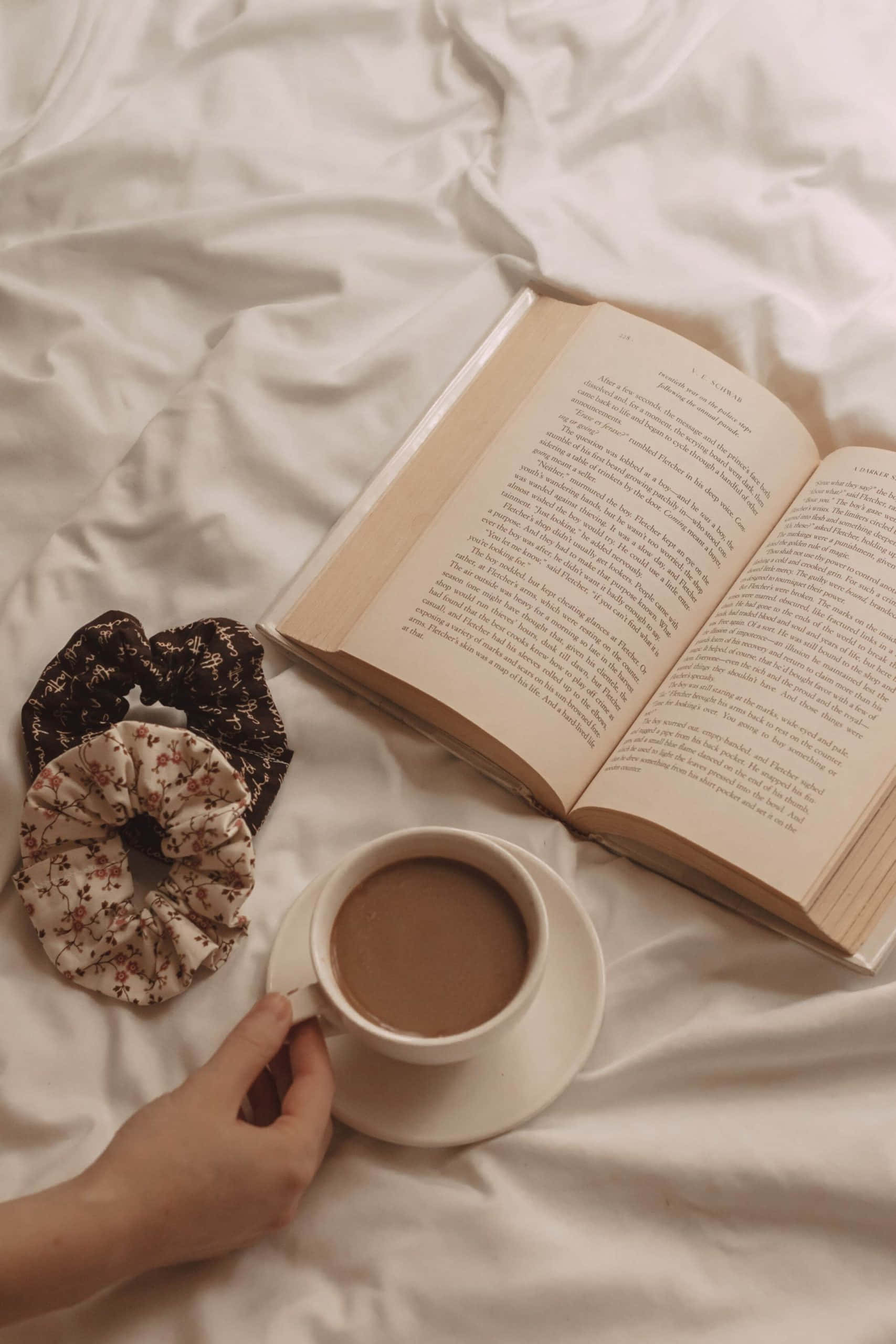 жінка тримає в руках книгу і чашку кави Шпалери