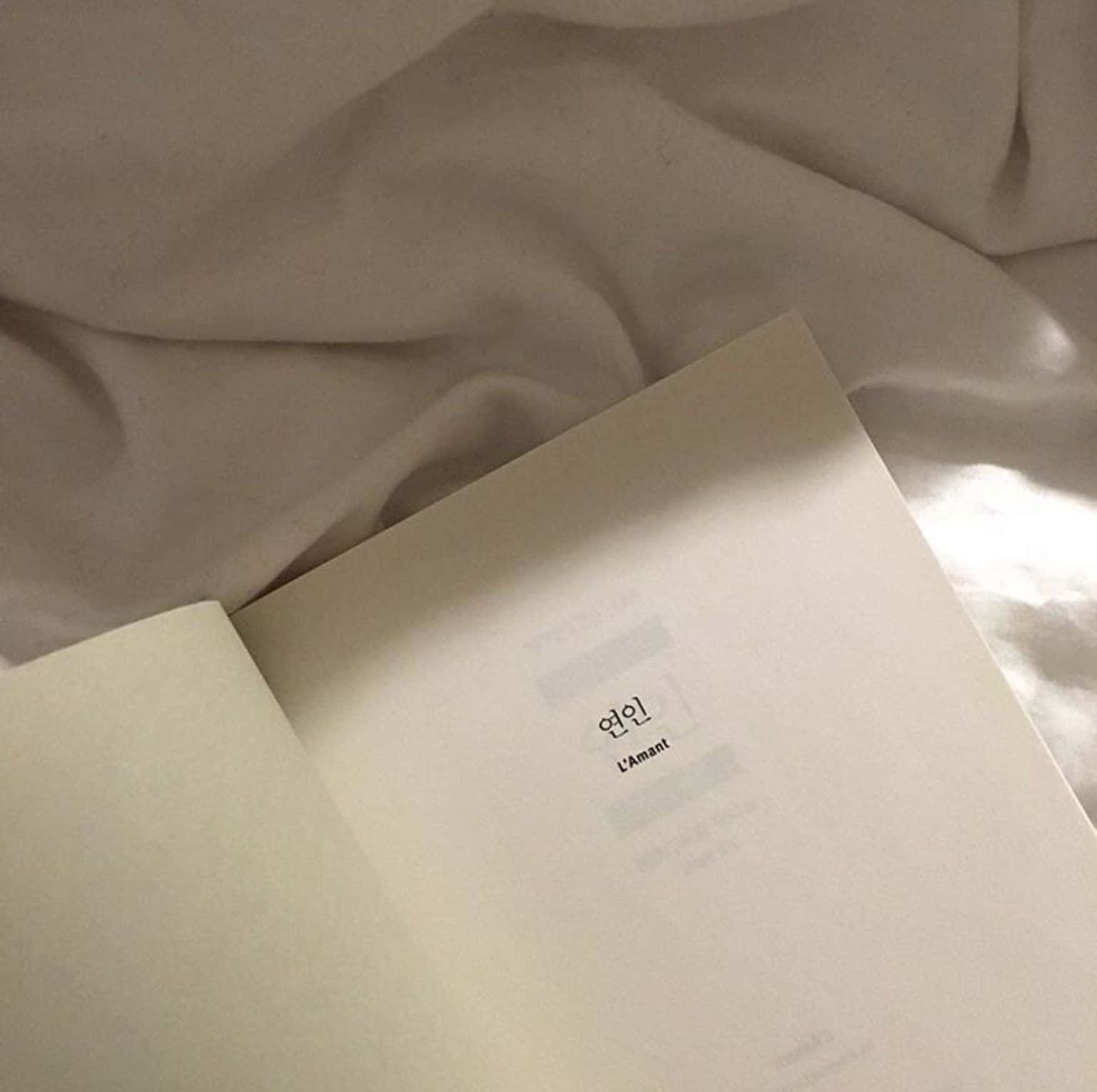 книга з білою обкладинкою на ліжку Шпалери
