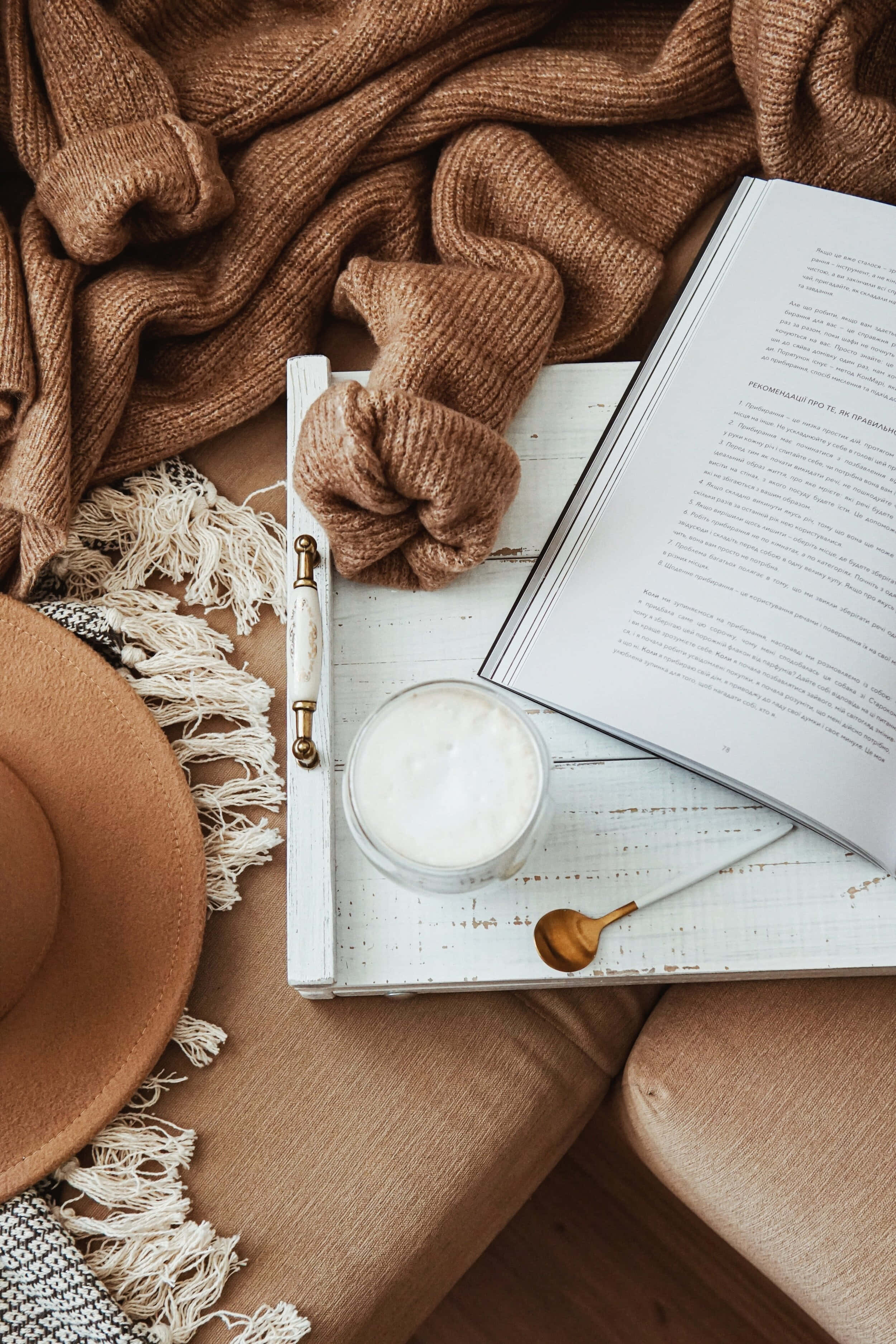 книга, капелюх і кружка на дивані Шпалери