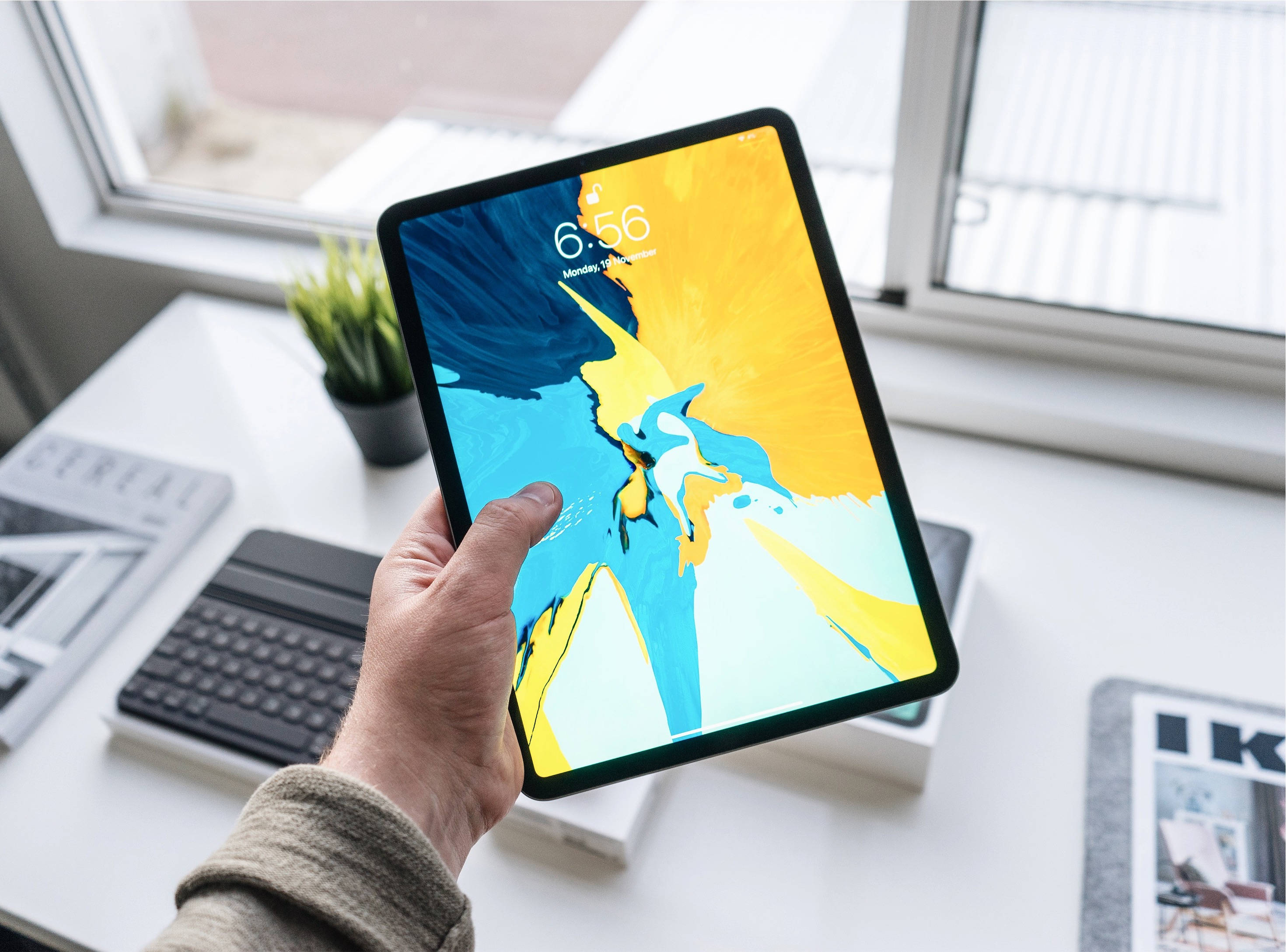 Людина держит Apple iPad Pro Шпалери