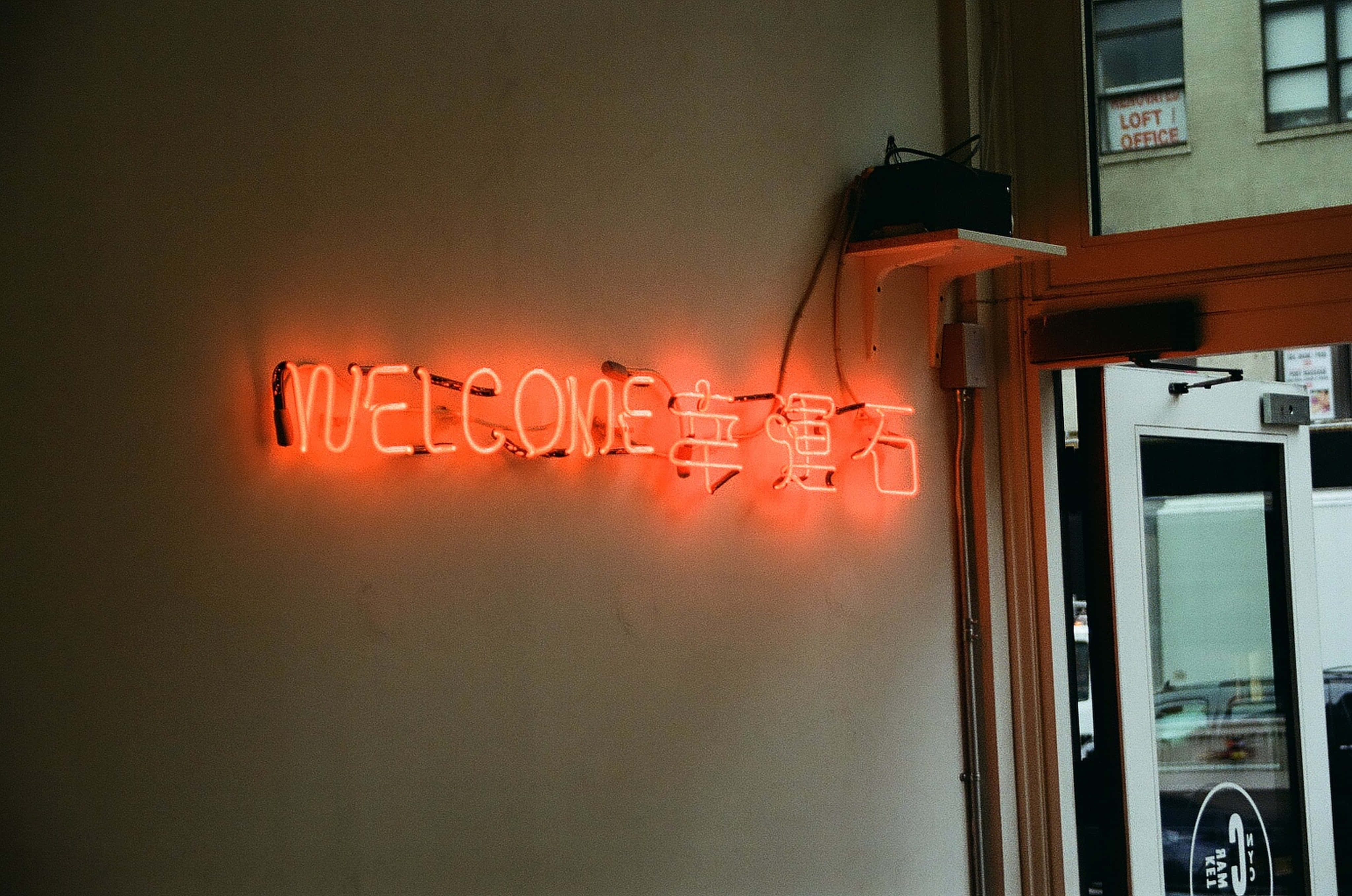 неоновая вывеска с надписью welcome на стене Шпалери