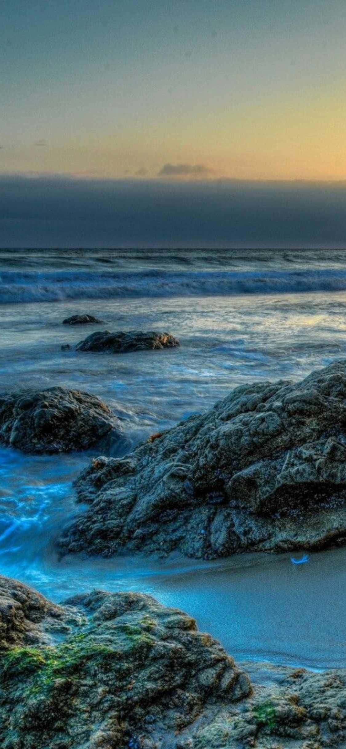 пляж с камнями и водой на закате Шпалери