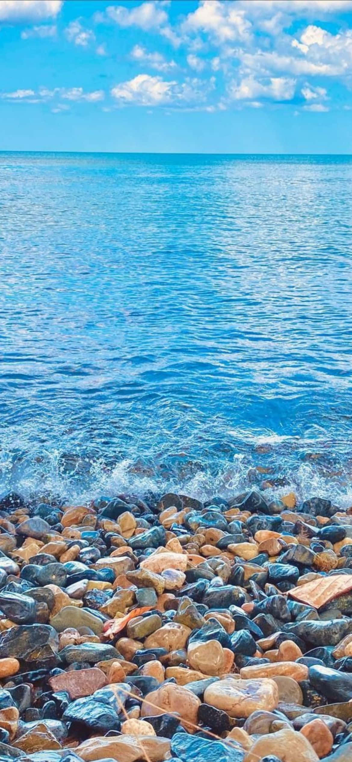 пляж с камнями і водой Шпалери