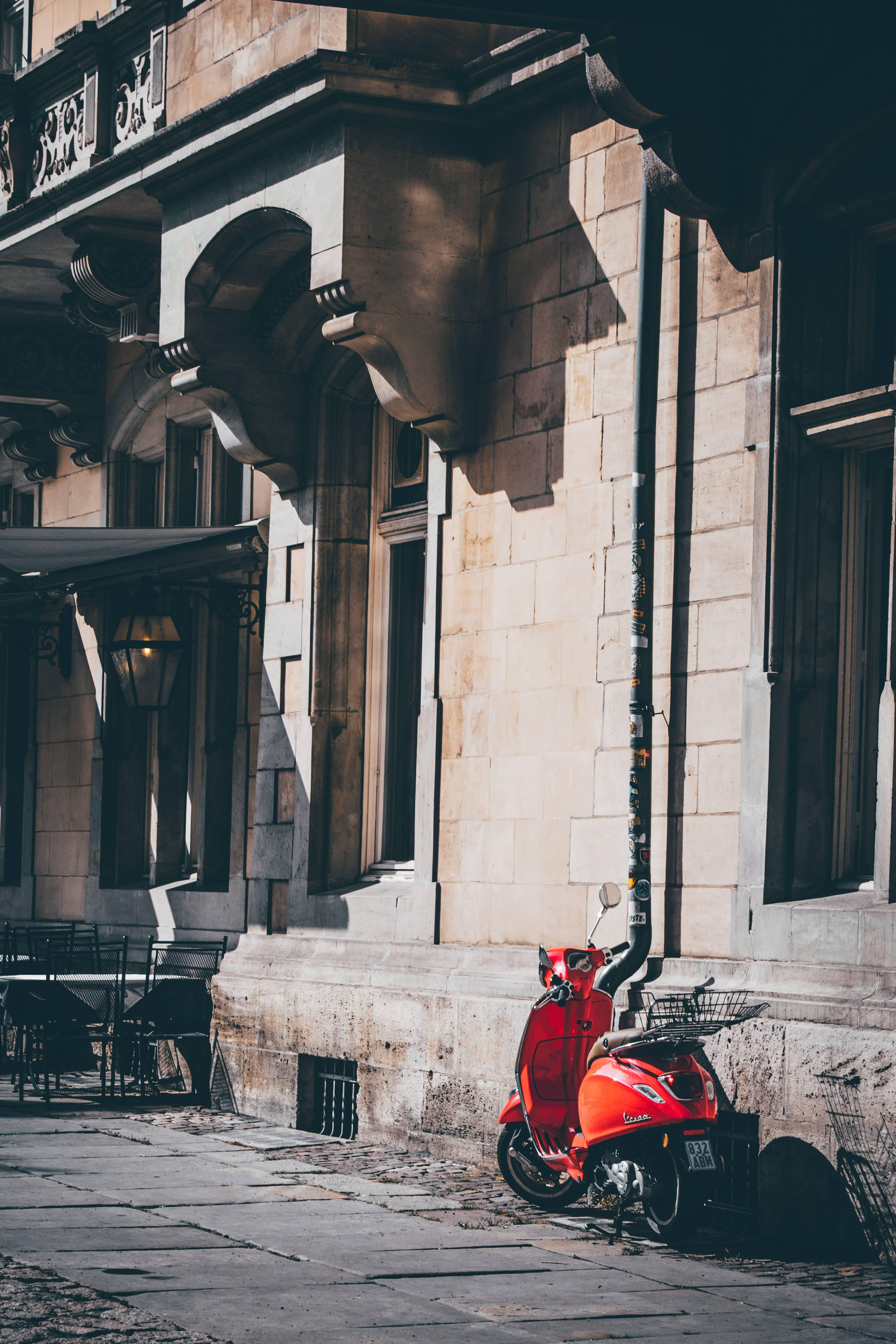 Современный красный мопед Vespa на улице Шпалери