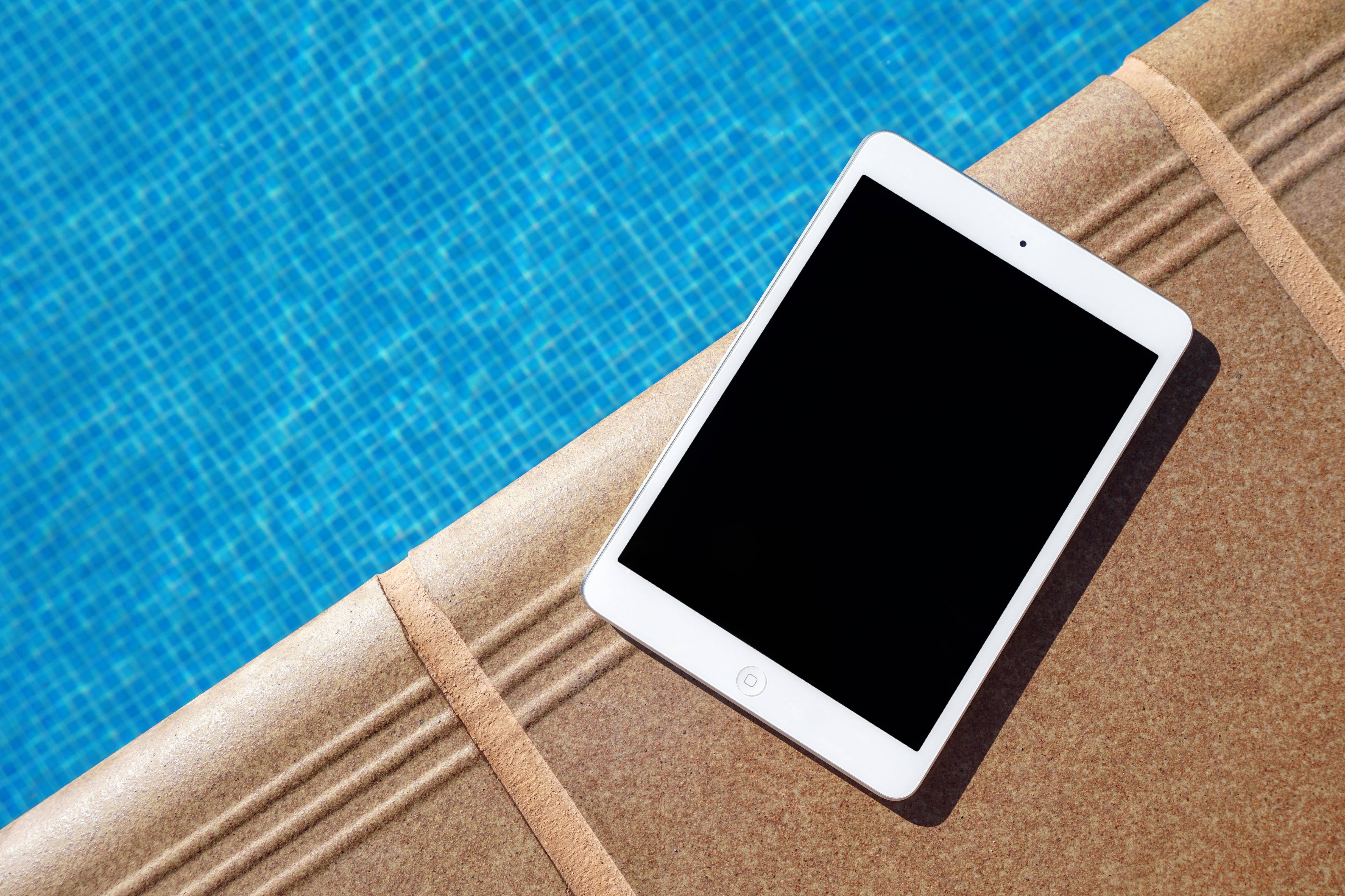 Стильный серебристый iPad на минималистичном сером столе Шпалери