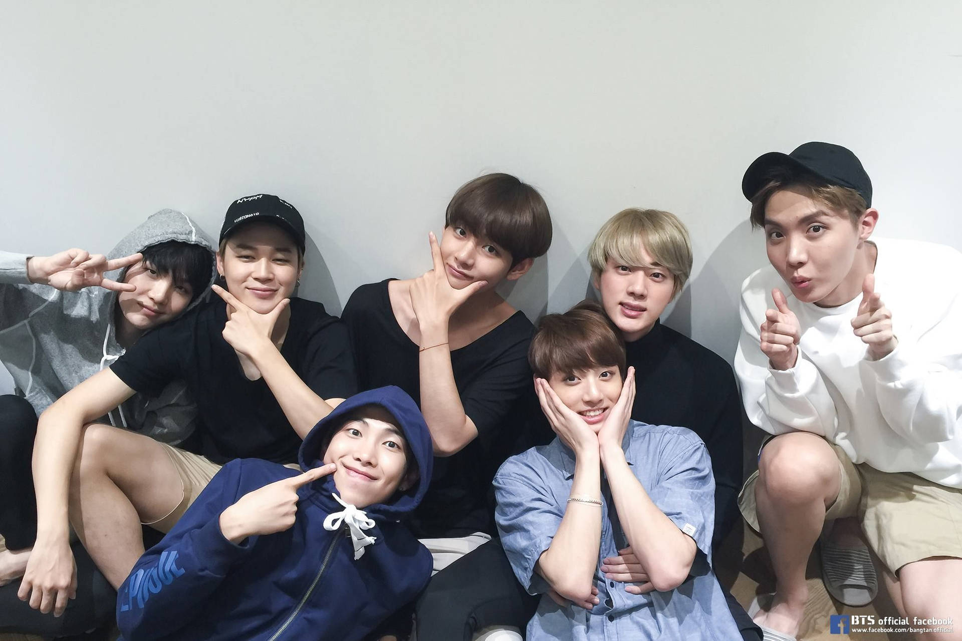 Група BTS усміхається і дивиться на вас.
