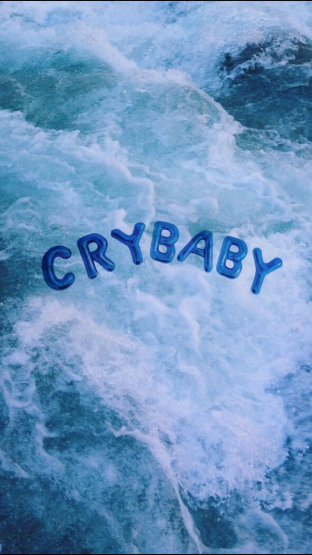 Крутий синій естетичний шпалер із великими кульковими літерами «Crybaby», що плавають на синьому океані чи морі.
