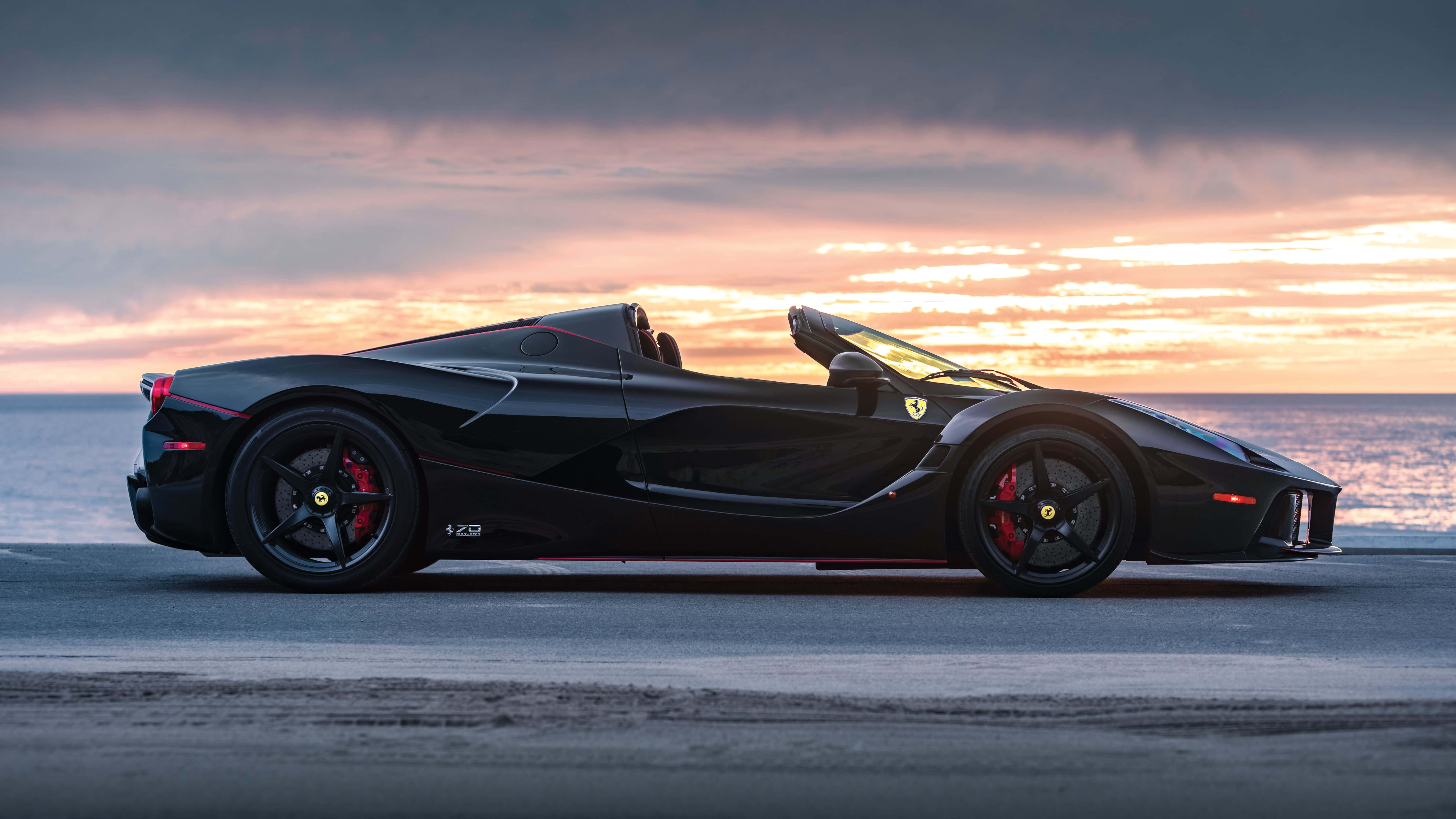 Чорне авто 4K Ferrari на заході сонця біля пляжу Шпалери