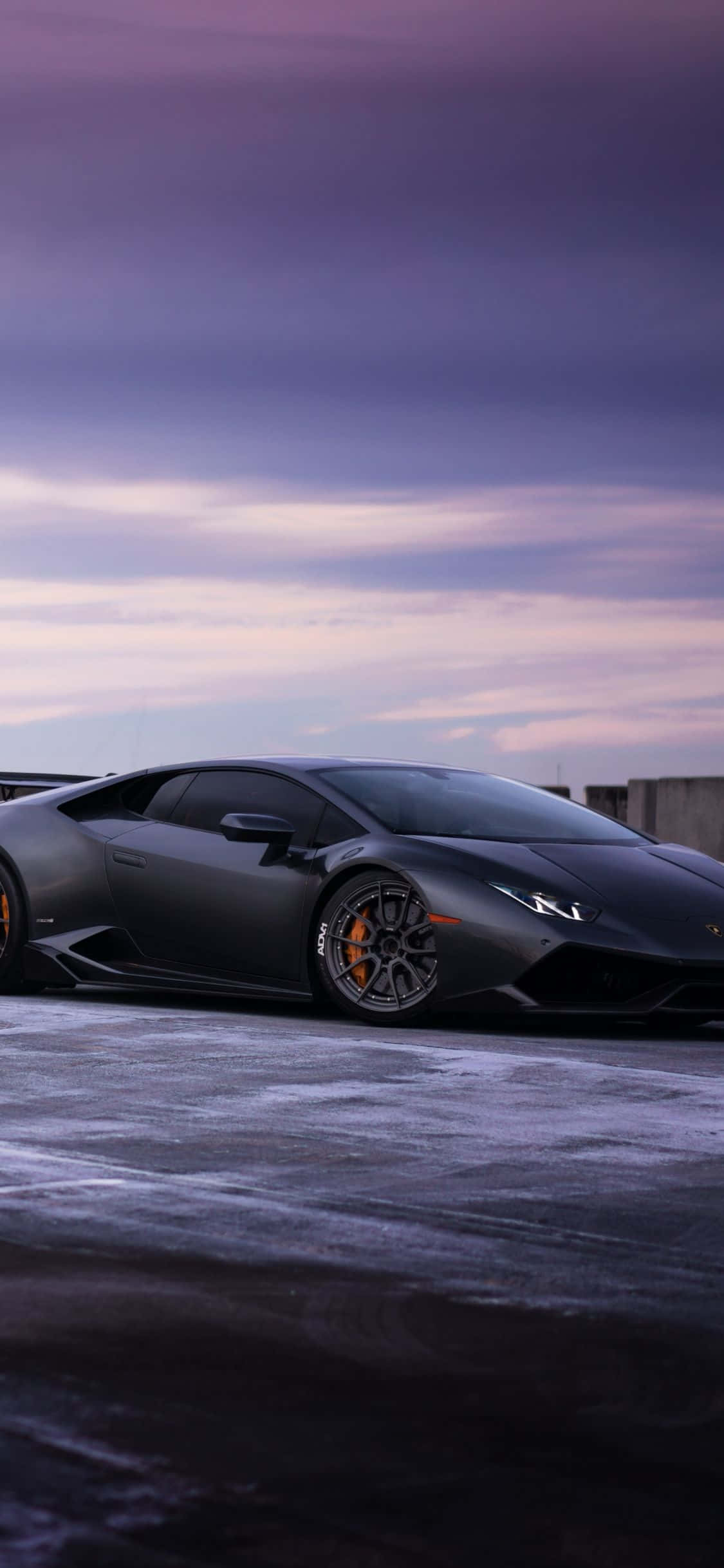 черный Lamborghini, припаркованный на заснеженной дороге Шпалери