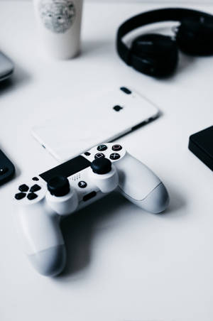 iPhone на столі с геймпадом PlayStation — Xiaomi Pad Шпалери