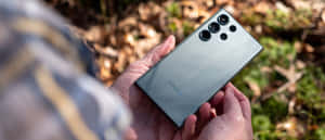 Samsung S23 Ultra в руке на природе — Samsung Galaxy S22 Шпалери