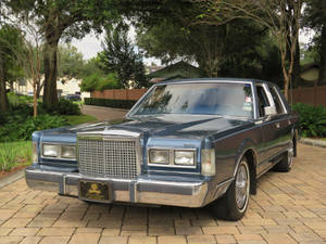 Величественный Lincoln Town Car 1986 года на асфальтированной подъездной дорожке — Автомобілі Шпалери