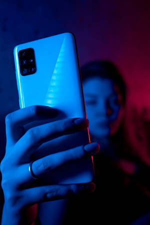 Женщина с телефоном в синем неоне iPhone — Xiaomi Pad 9 Pro Max Шпалери