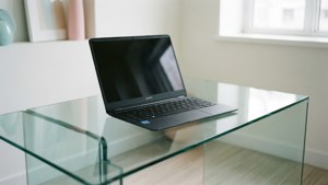 Чиста мінімалістична сцена с Chromebook на скляному столі.