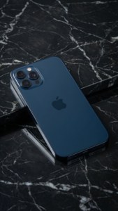 iPhone 17 у опівнічному синьому кольорі на мармурі, мінімалістичне студійне фото.