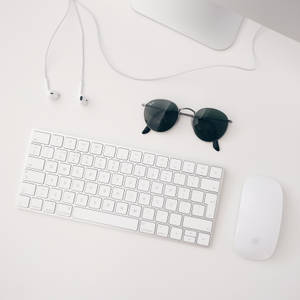 Минималистичные обои с белым комплектом Apple MAC, состоящим из iMAC, беспроводной клавиатуры, магической мыши и наушников.