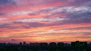 Барвисте небо на світанку над силуетом міської забудови. — Вид на небо Шпалери