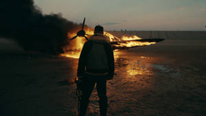 Том Харди в роли Фарриера в фильме «Дюнкерк» смотрит на горящий самолет обои.